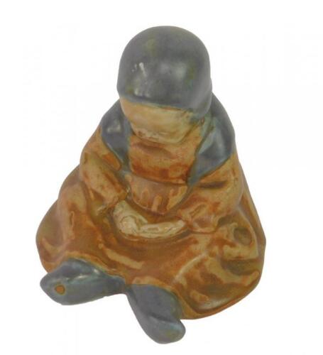 An early 20thC Quimper figure of a seated child