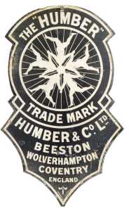THE 'HUMBER' enamel advertising sign, shaped as a clock face depicting five interlinked figures,...