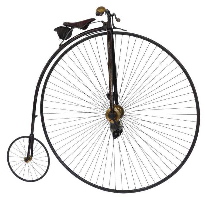 A 19thC penny farthing or ordinary bicycle, the black and red painted frame with a brass bell...