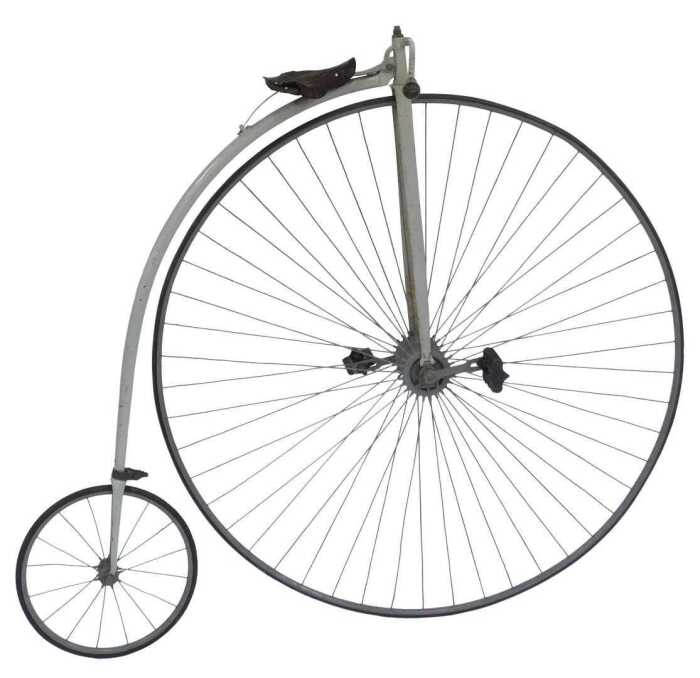 A penny farthing or ordinary bicycle, the painted grey frame with a partial leather seat, and...