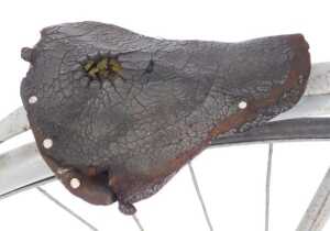 A penny farthing or ordinary bicycle, the painted grey frame with a partial leather seat, and... - 4