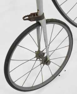 A penny farthing or ordinary bicycle, the painted grey frame with a partial leather seat, and... - 6
