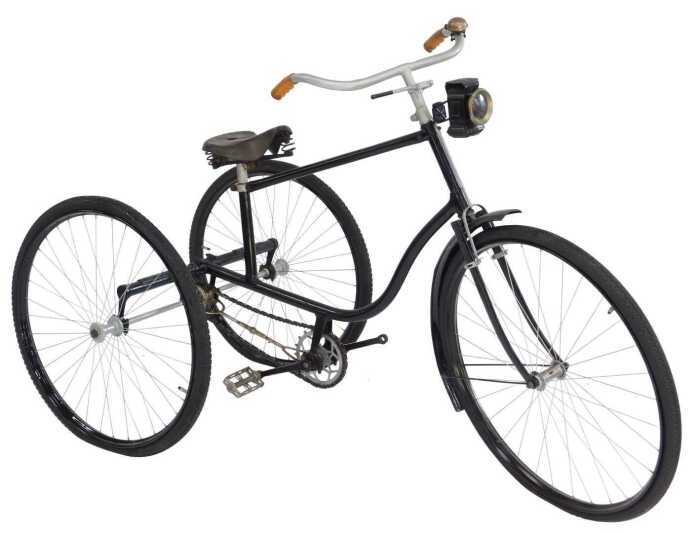 A tricycle, the black painted frame with steel and orange plastic capped handlebars, with a...
