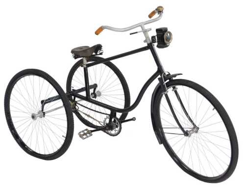 A tricycle, the black painted frame with steel and orange plastic capped handlebars, with a...