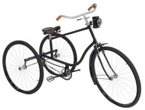 A tricycle, the black painted frame with steel and orange plastic capped handlebars, with a...