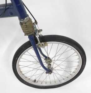 A Moulton bicycle, the royal blue frame with a black seat, lacking pedals, on a single bicycle... - 6