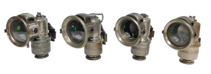 Four Powell and Hanmer Ltd Birmingham carbide/acetylene bicycle lamps, each inset with red and...