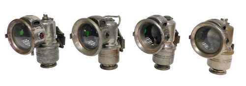 Four Powell and Hanmer Ltd Birmingham carbide/acetylene bicycle lamps, each inset with red and...