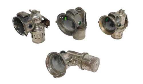 Four Miller Bola carbide/acetylene bicycle lamps, each inset with faceted green glass roundels,...