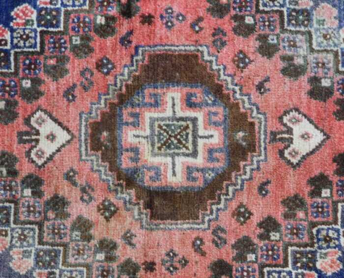A Persian rug, red and blue ground, decorated with central medallion ...