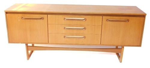 A Portwood Furniture vintage teak sideboard, with three central drawers flanked by a pair of cupboard doors, raised on U shaped ends, 75cm high, 184cm wide, 44cm deep.