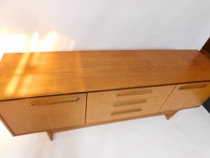 A Portwood Furniture vintage teak sideboard, with three central drawers flanked by a pair of cupboard doors, raised on U shaped ends, 75cm high, 184cm wide, 44cm deep. - 2