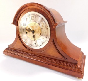 A Franz Hermle mahogany cased mantle clock, circular silvered dial bearing Arabic numerals with central foliate fret work, eight day movement, with Westminster chimes, the case of Napoleon hat form, with key, 29cm high, 46cm wide. (AF) - 3