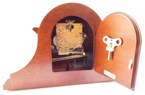 A Franz Hermle mahogany cased mantle clock, circular silvered dial bearing Arabic numerals with central foliate fret work, eight day movement, with Westminster chimes, the case of Napoleon hat form, with key, 29cm high, 46cm wide. (AF) - 4