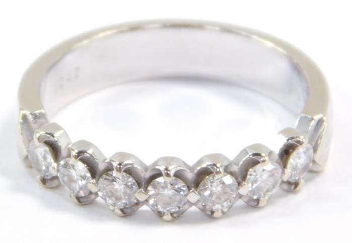 A diamond seven stone half hoop eternity ring, set in white metal, stamped 18k, approximately a 0.25ct, size M, 3.5g.