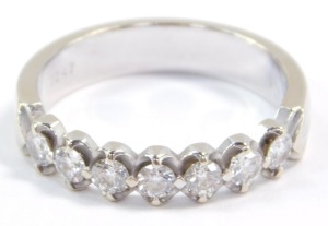A diamond seven stone half hoop eternity ring, set in white metal, stamped 18k, approximately a 0.25ct, size M, 3.5g.