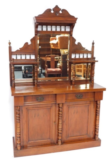 A Victorian walnut chiffonier, or side cabinet, the raised back with three bevelled mirrored plates, on turned supports, the base with two frieze drawers above to panelled doors, flanked by turned pillars on a plinth, 192cm high, 119cm wide.