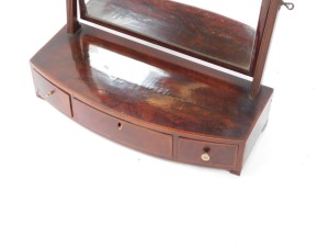 A George III flame mahogany and satinwood cross banded toilet mirror, the rectangular swing frame mirror above a bow fronted base, having one long and two short drawers, raised on bracket feet, 54cm high, 57cm wide, 24.5cm deep. - 2