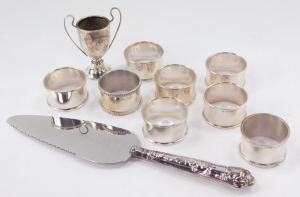 A set of six Elizabeth II silver napkin rings, by Francis Howard Ltd, Birmingham 1962, with a pair of additional napkin rings, a commemorative cup and a silver handled cake slice, 5.32oz all in. - 2