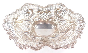 A Victorian silver centrepiece bowl, having elaborate scrolled and floriate rim, surrounding a multi patterned pierced lattice work design, with heart shaped moulded scrolls, surmounted by ribbon bows, with centre oval reservoir, raised upon a quadriparti - 4