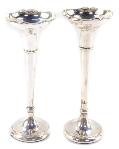 Two George V silver bud vases, having a moulded bowl, above a tapering cylindrical stem with flared base, both with loaded bases, 7cm and 8cm respectively.