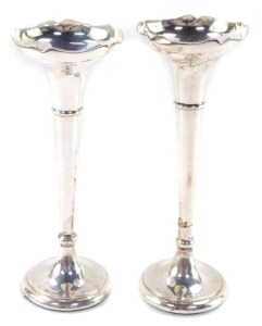 Two George V silver bud vases, having a moulded bowl, above a tapering cylindrical stem with flared base, both with loaded bases, 7cm and 8cm respectively.