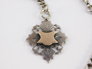 An Edwardian silver graduated curb link watch chain, terminating upon T bar and watch link, with additional fob chain having diamond shaped fob, with vacant cartouche, Herbert Bushell, Birmingham 1902, 1.98oz all in, total length 34cm. - 2