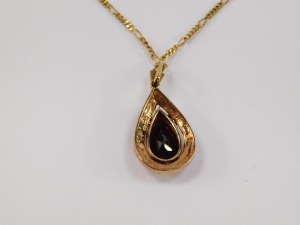 A Continental pendant, having pear cut garnet, surrounded by seed pearls, surmounted by fluted fitting, in yellow metal, with associated Italian fancy link chain marked 9ct, total length 53cm . - 3