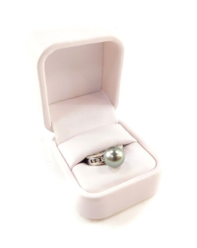 A 14ct white gold Tahitian cultured pearl and diamond ring, the high set pearl flanked by channel diamond set shoulders, pearl approx 10.5mm diameter, diamonds approx 0.3ct, size N, 8.8g.