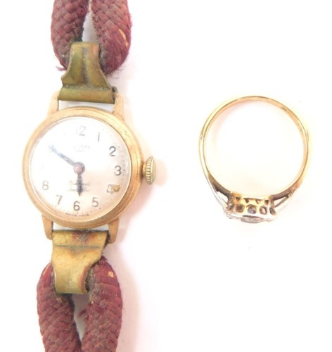 An 18ct gold platinum sapphire and diamond ring, in a circular design, size J, 2.5g, together with a Rotary lady's 9ct gold cased wristwatch, silvered dial bearing Arabic numerals, jeweled movement, on a leather strap. (2)
