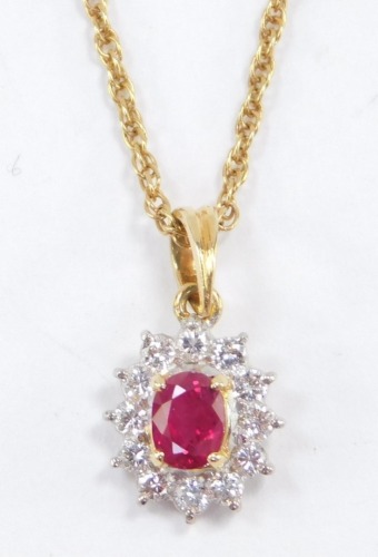 A diamond and ruby oval cluster pendant, on a yellow metal neck chain, stamped 585, 3.3g.