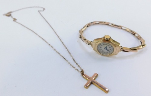 A lady's mid century 9ct gold cased wristwatch, circular silvered dial bearing Arabic numerals, on a bracelet strap, together with a 9ct gold cross on chain, 12.5g all in.