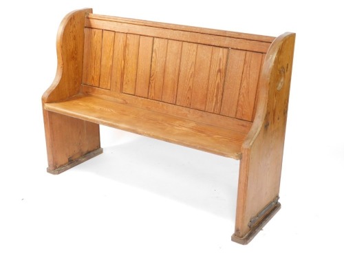 A Victorian pitch pine pew, the shaped ends carved with roundels, 132cm wide.