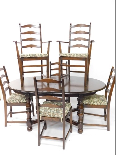An elm dining room suite, comprising an oval extending dining table with moulded edge, turned legs and x shaped stretcher, and a set of six ladderback chairs, comprising a pair of carvers and four single chairs.