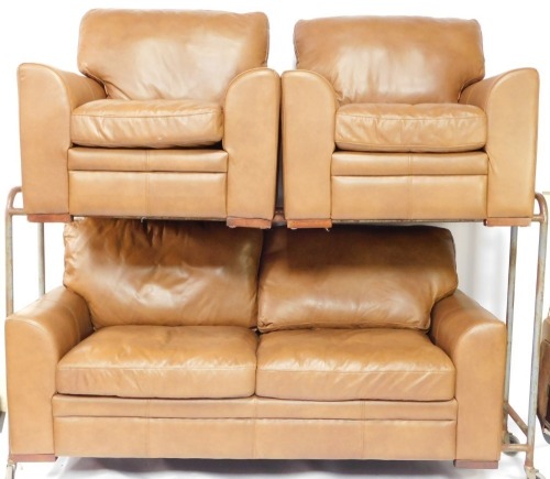 A brown leather three piece suite, comprising three seat sofa with shaped arms and block feet, and two matching armchairs, the sofa 193cm wide.