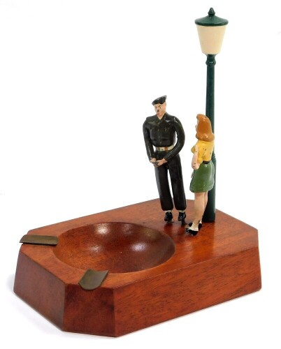 A WWII German Prisoner of War made ashtray, modeled with figures, Underneath The Lamplight, made famous by Lili Marlene and Vera Lynn, detail to base, Egypt, November 21 1946., 10cm wide, 14cm deep.