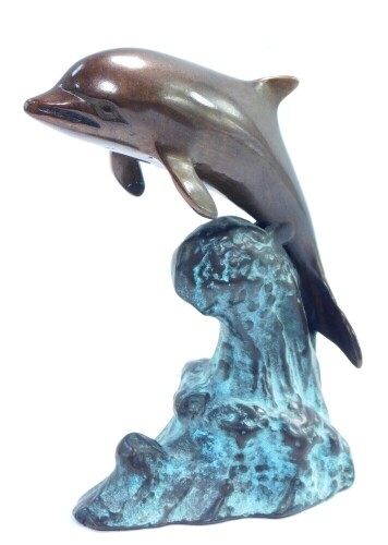 A bronze figure of a dolphin, modeled riding on the crest of a wave, 16cm high.