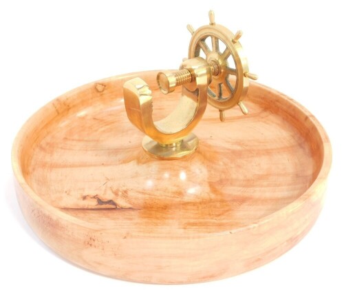 A novelty brass capstan wheel nut cracker, mounted on a walnut bowl, 26cm wide.