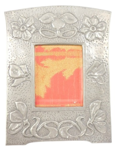 An Arts & Crafts pewter wall mounted photograph frame, embossed with flowers, berries and leaves, aperture 14.5cm high, 11cm wide, frame 32.5cm high, 24cm wide.