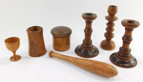 A group of treen, comprising a circular spice box and cover, three candlesticks, tapering vase, egg cup and pocket truncheon. (7)