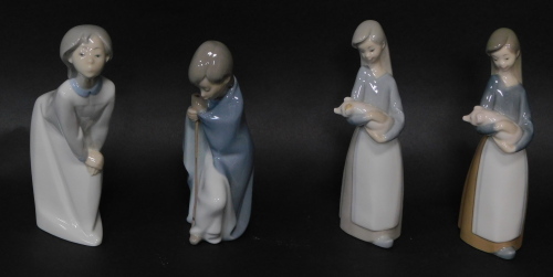 Four Lladro porcleian figures modlled girls, all standing, two holding piglets, 18cm high.