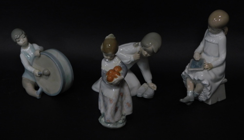 Four Lladro figures of children, three marked Lladro, child with chalk board, unmarked, the tallest figure 19cm high.