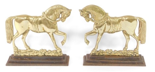A pair of Victorian cast brass door stops or porters, in the form of profiled horse, on integral cast iron stepped bases, 24cm high.