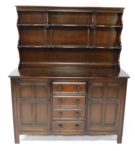An Ercol elm dresser, the raised back with two plate shelves, the base with a moulded edge above four drawers, flanked by two paneled doors on stiles, 170cm high, 144cm wide.