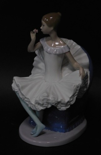 A Nao porcelain figure of a ballerina, modelled seated in an armchair, 25cm high.