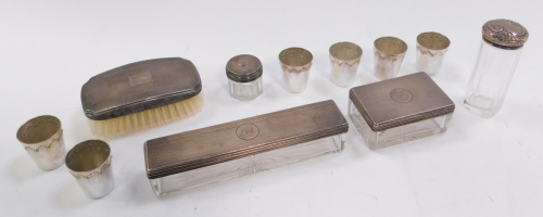 A group of silver mounted cut glass dressing table items, each with engine turned decoration, to include two rectangular glass jars, with decorated lids, bearing initials, London 1847, and a set of six Russian silver plated Vodka cups.