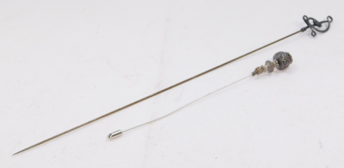 A silver mounted hat pin, with scroll finial by Charles Horner, Chester 1919, and another hat pin, (2).