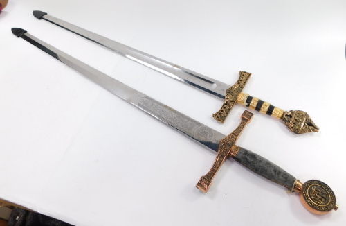 Two replica swords, one stamped King Arthur Excalibur, each with a gilt metal pommel and handle, decorated with Celtic motifs, etc., 122cm long overall.