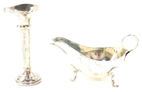 A George VI silver sauce boat, raised on three hoof feet, Sheffield 1945, 5.14oz., together with a loaded silver bud vase, of trumpet form, Birmingham 1961, 13cm high, 2.10oz all in. (2)