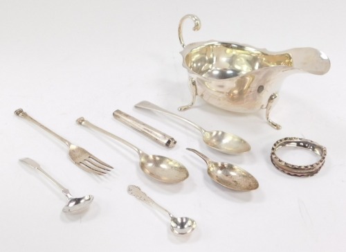 A George V silver sauce boat, with C scroll handle, raised on three paw feet, Sheffield 1932, seal top, fork and spoon, Sheffield 1959, further spoons, and a napkin ring, 8.13oz.